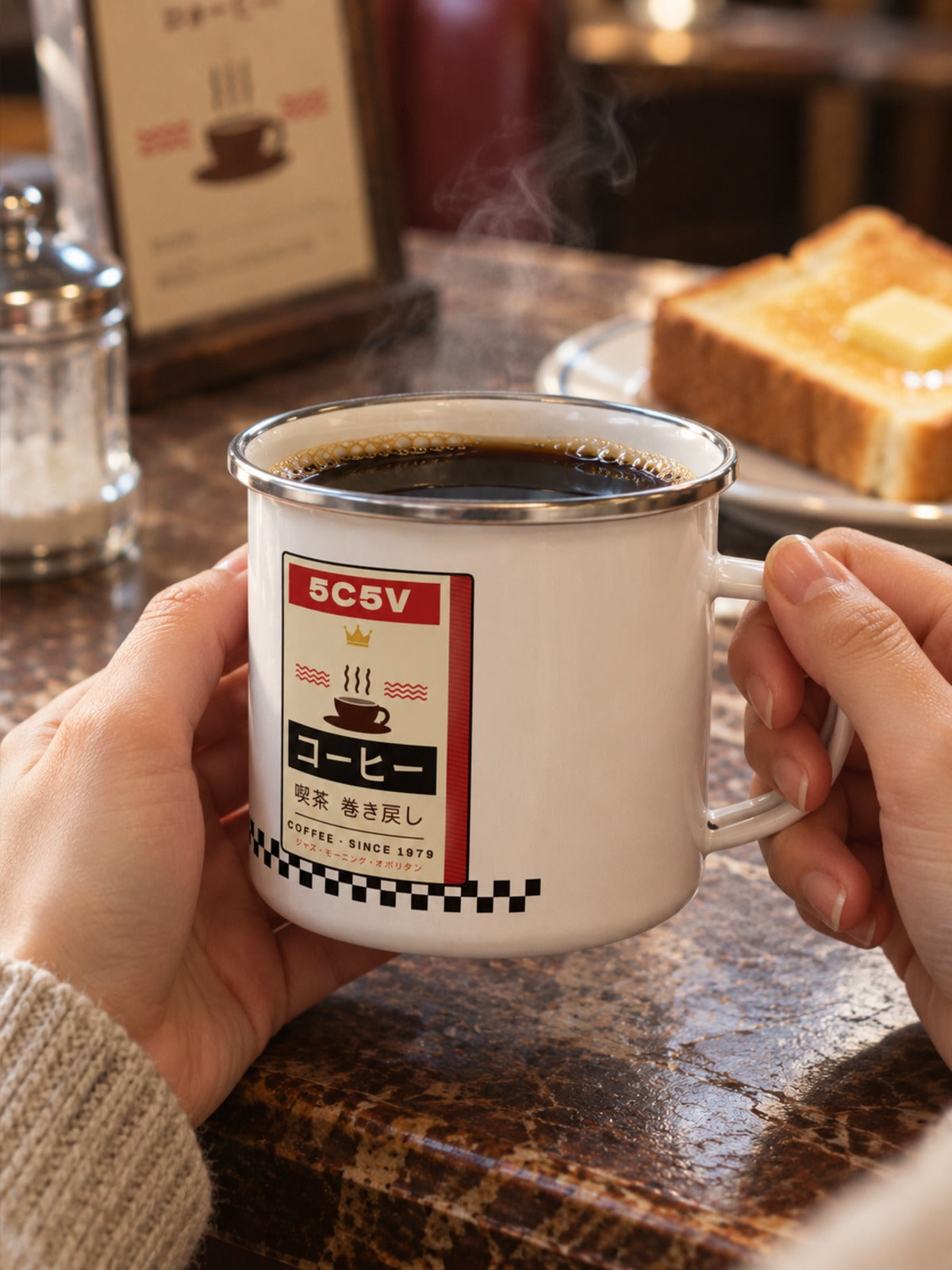 Kissaten 喫茶 Japanese Coffee Enamel Mug by 5C5V held in two hands, 5C5V label side