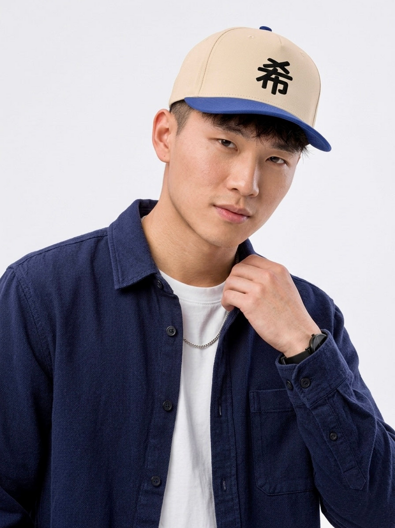 Model in a navy overshirt wearing the Sapporo Hope 希 baseball cap in royal and natural