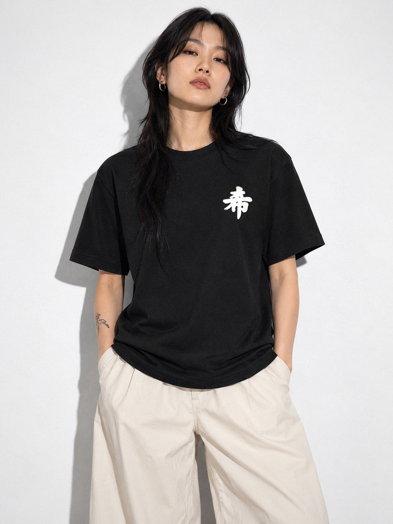 Model with a long black wolf cut wearing the black Sapporo Hope 希 premium oversized tee, white 希 kanji embroidered on the chest