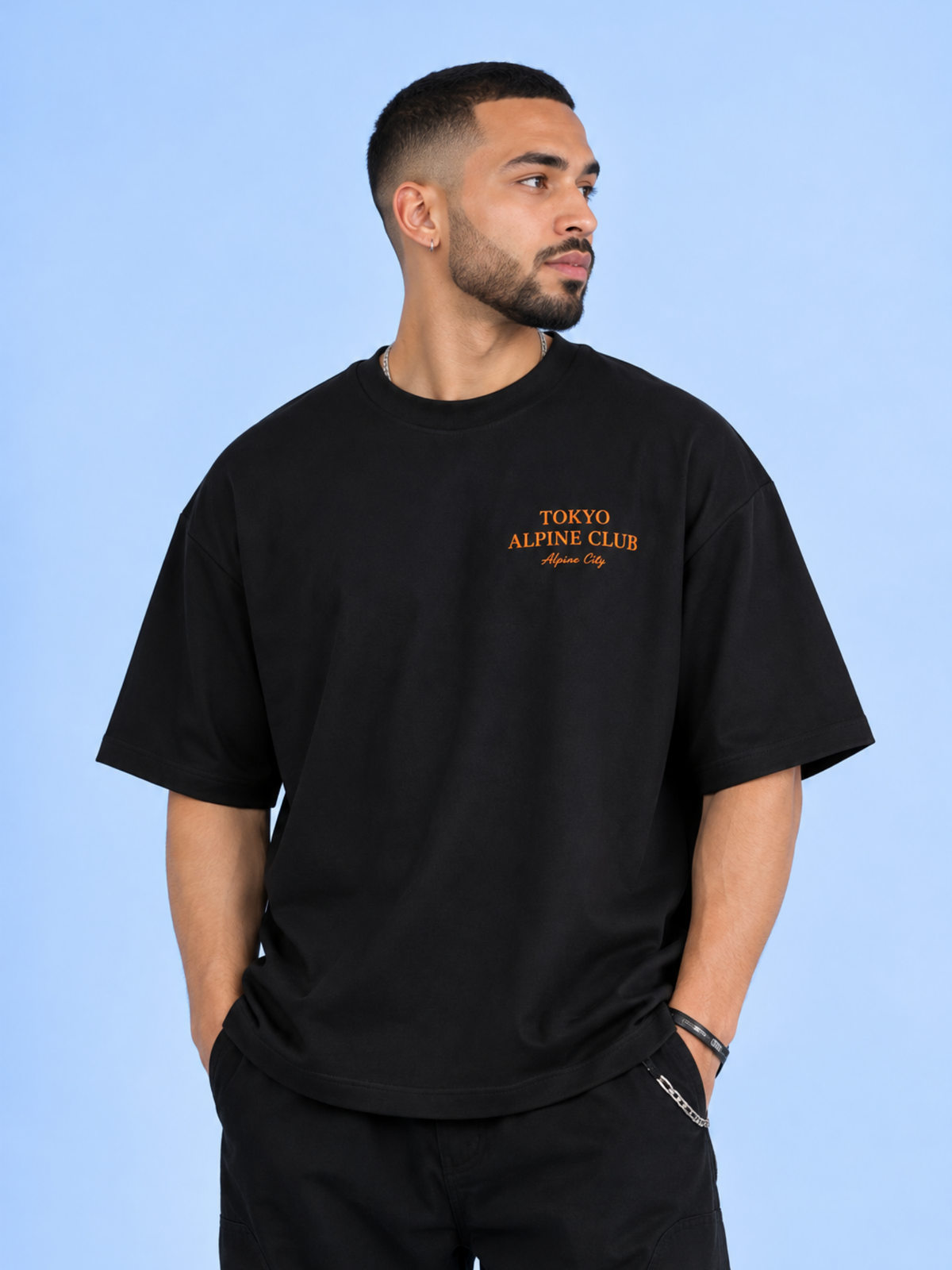 Model wearing the black Tokyo Alpine Club tee, front view with the orange Tokyo Alpine Club chest print
