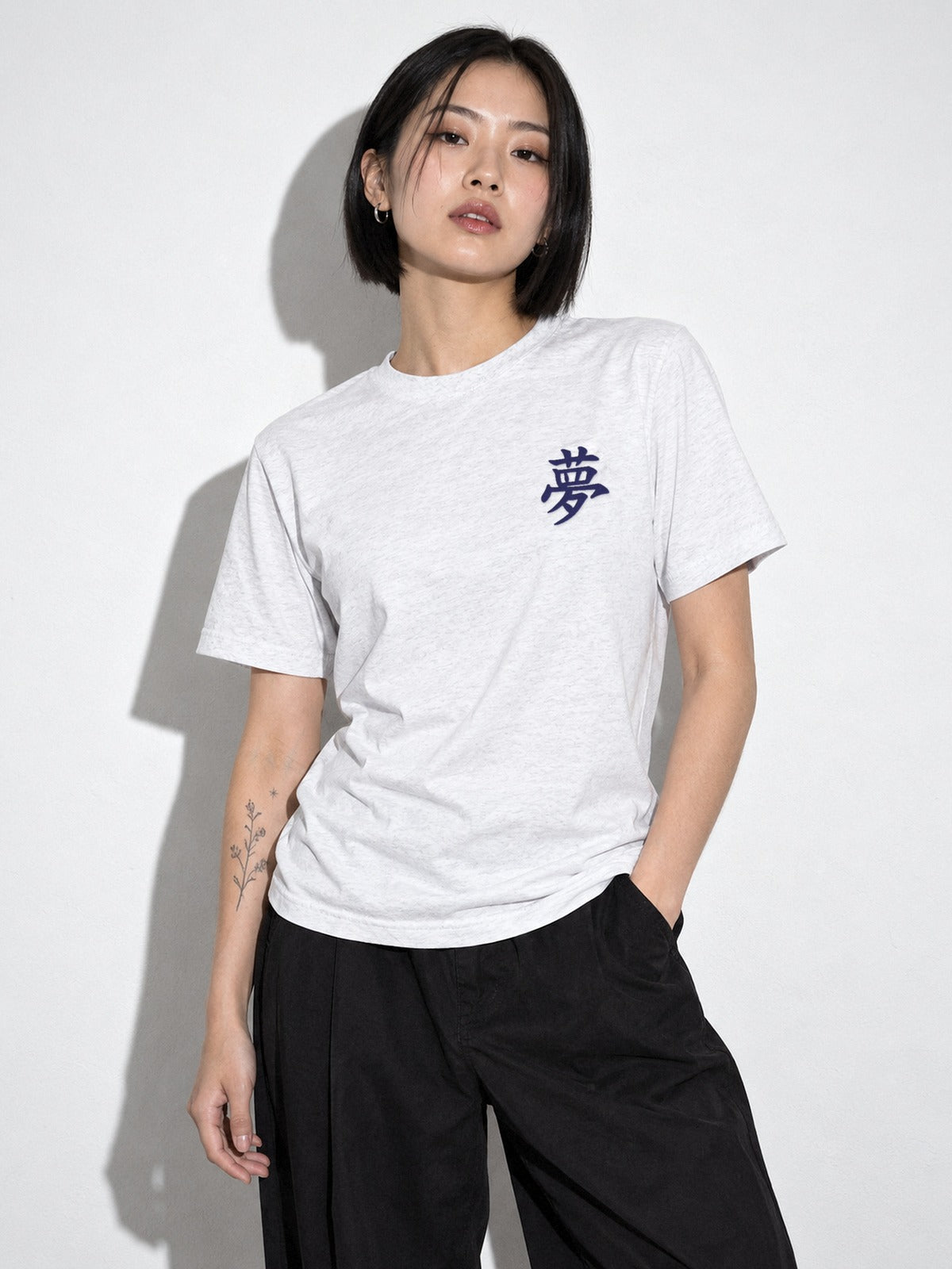 Model with a black bob wearing the white tri-blend Tokyo Dream 夢 tee, navy 夢 kanji embroidered on the left chest
