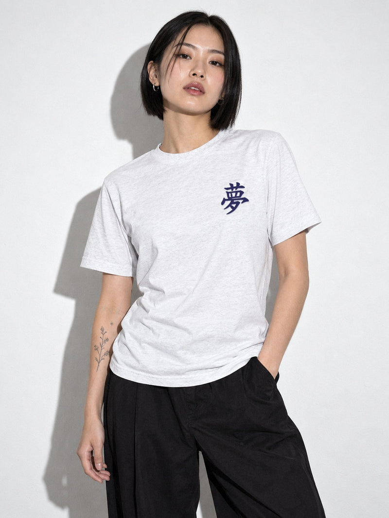 Model with a black bob wearing the white tri-blend Tokyo Dream 夢 tee, navy 夢 kanji embroidered on the left chest