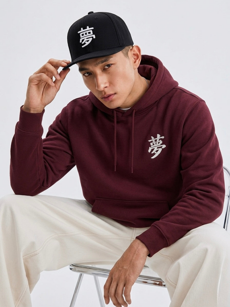 Model in a burgundy hoodie wearing the black Tokyo Dream 夢 snapback