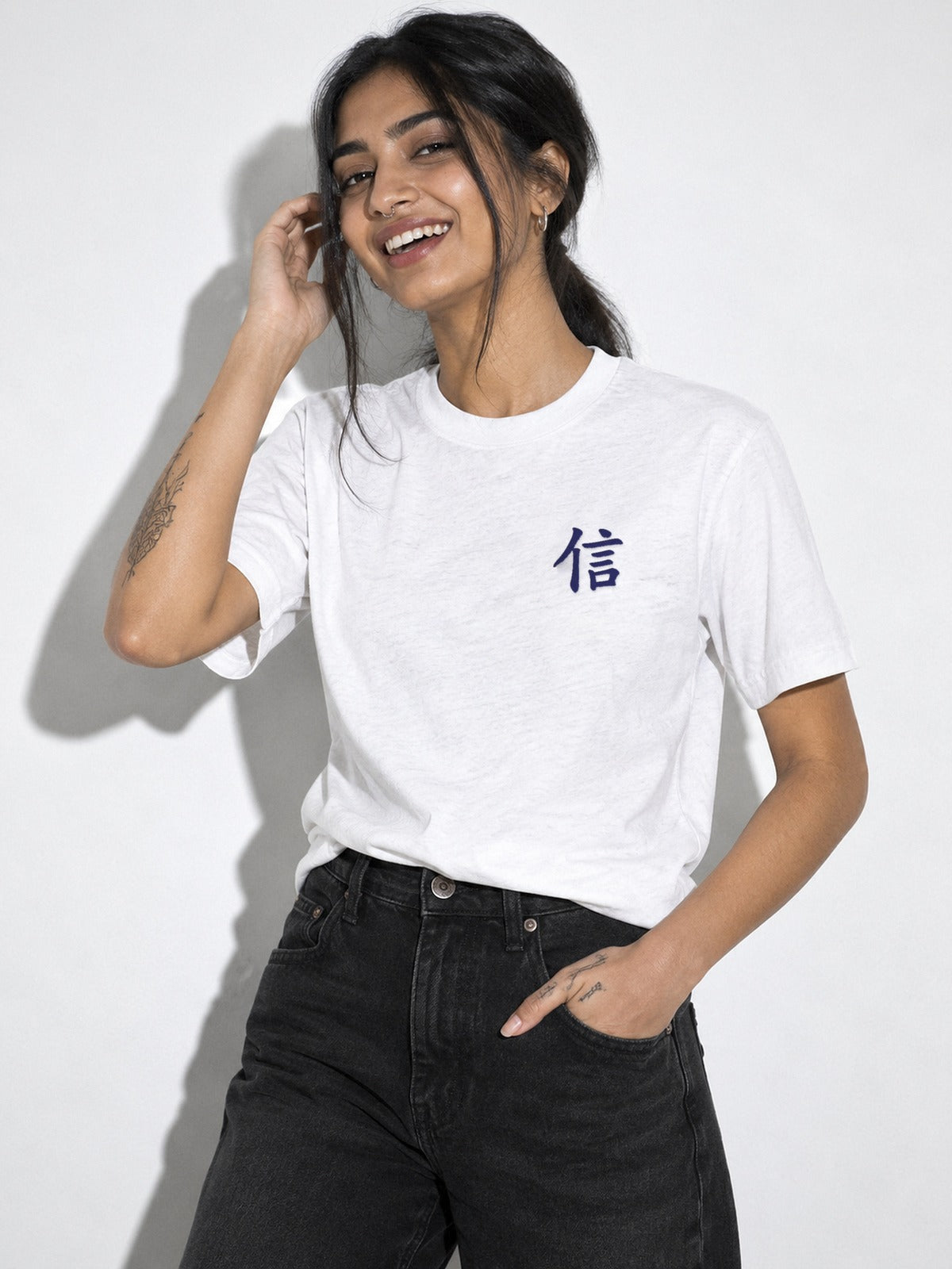 Laughing model in the white tri-blend Yokohama Trust 信 tee, navy 信 kanji embroidered on the left chest